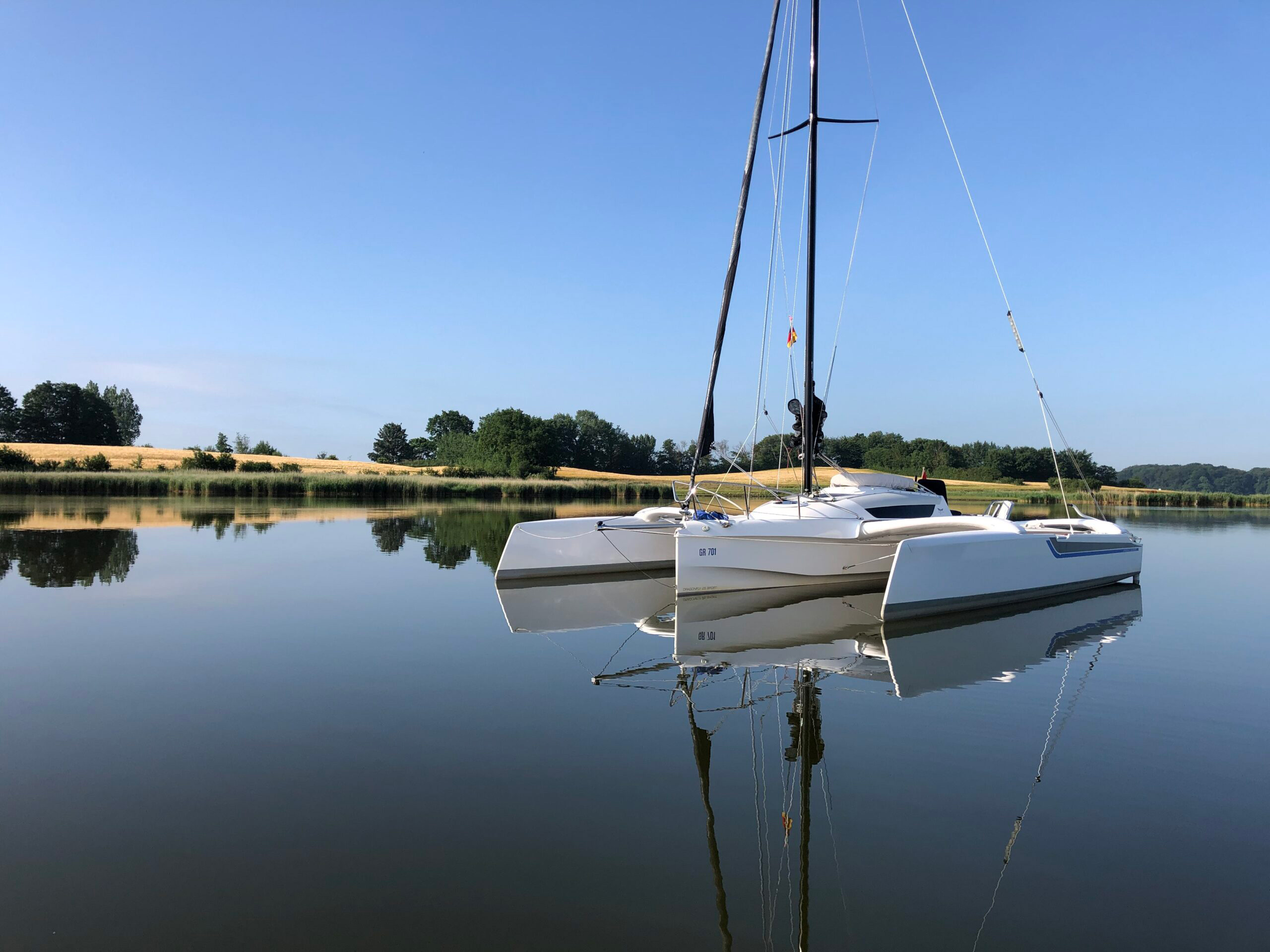 Dragonfly 25 trimaran at anchor with outriggers fully extended