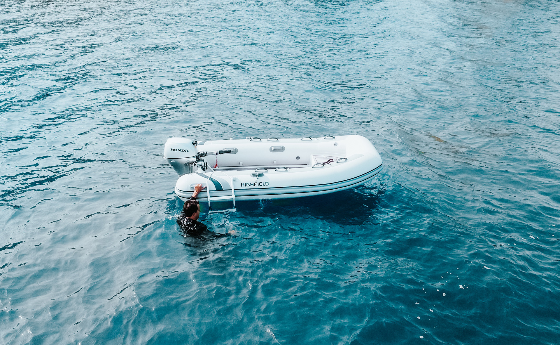 Highfield CL310 aluminium-hull inflatable tender cruising through clear blue water