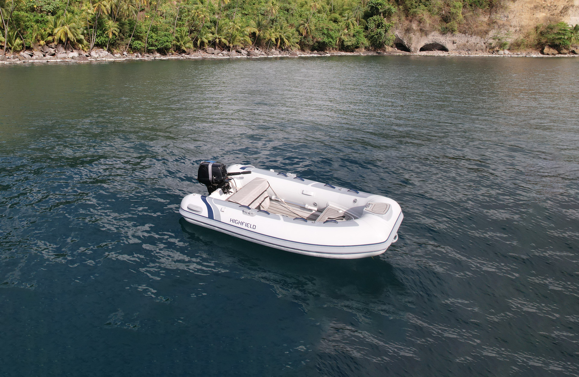 Highfield CL290 aluminium-hull inflatable tender floating near a tropical coastline