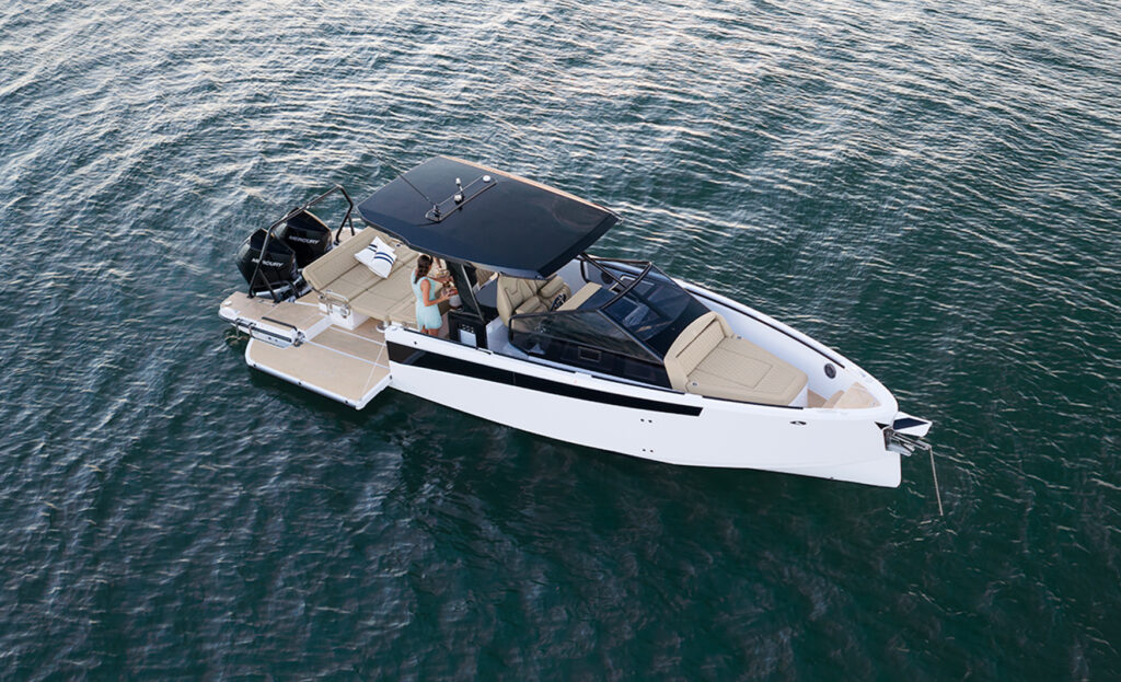 Elevated view of the Virtue V33 Top cruising on the water, highlighting its open deck layout and sleek exterior.